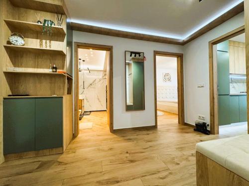 a living room with wood floors and a room with a counter at Chic Center Apartament in Braşov