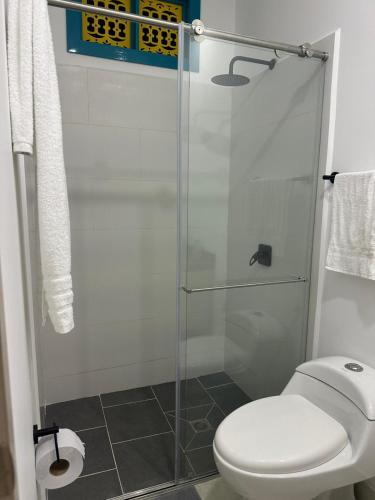 a bathroom with a toilet and a glass shower at Encantador y acogedor Apartamento in Filandia