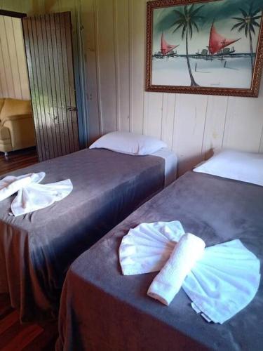 a room with two beds and a picture on the wall at Casa Lar Azul in Rio Forcação
