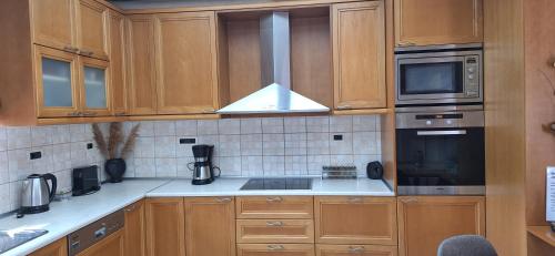 a kitchen with wooden cabinets and a stove top oven at Modern Villa in Chania in Perivólia