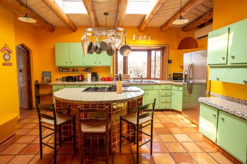 a kitchen with green cabinets and a table with chairs at Casa Corazon in Santa Fe