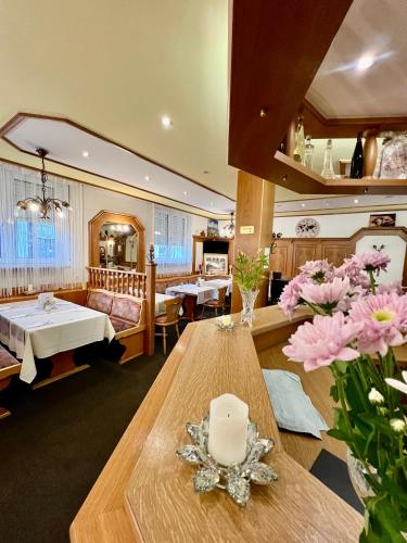 a living room with a table with flowers on it at Hotel Residenz Stockstadt in Stockstadt am Main