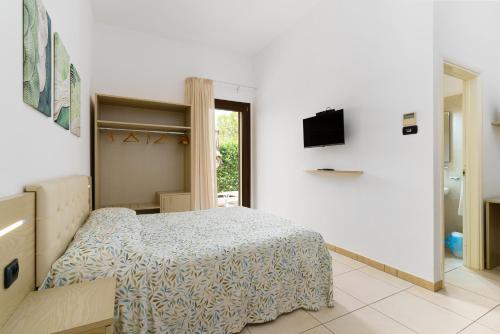 a bedroom with a bed and a tv on a wall at Delle Rose, Hotel & Horse Riding in Torre Vado