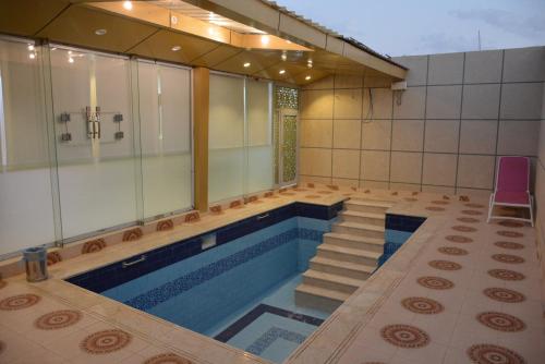 a swimming pool with a tub and stairs in a house at شقق زائر الشمال للشقق المخدومه in Sakakah