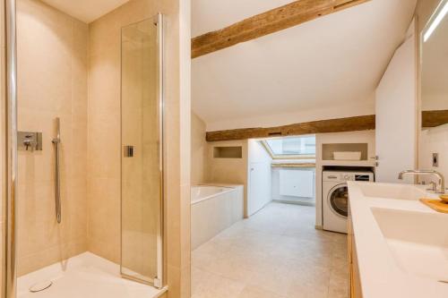 une salle de bain avec douche et lavabo et une machine à laver dans l'établissement Cosy Duplex in the heart of Beaupassage, à Paris