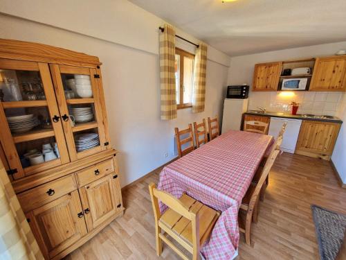 - une cuisine avec une table, des placards en bois, une table et des chaises dans l'établissement Spacieux appartement 4 pièces pour 8 pers, au cœur de la station, proche télécabine et commerces - FR-1-265-64, à Valfréjus