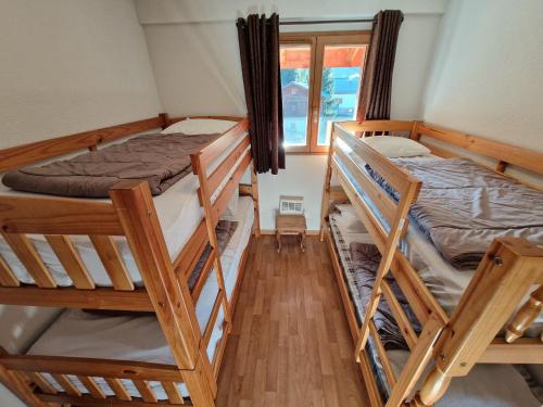 une chambre avec deux lits superposés et une fenêtre dans l'établissement Spacieux appartement 4 pièces pour 8 pers, au cœur de la station, proche télécabine et commerces - FR-1-265-64, à Valfréjus