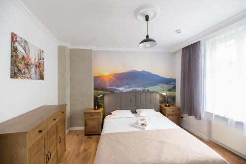 una camera da letto con un letto e un murale di montagna sul muro di Sunset Apartaments - Sunflower a Toruń
