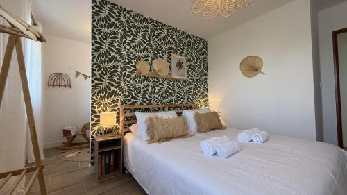 une chambre avec un lit blanc avec des serviettes dessus dans l'établissement Le Clos Du Moulin 4 - Maison, jardin, 3 chambres, wifi, clim, parking gratuit, à Entraigues-sur-la-Sorgue