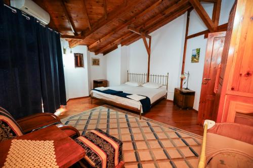 una camera da letto con un letto, un tavolo e delle sedie di Zhivka House a Glavatartsi