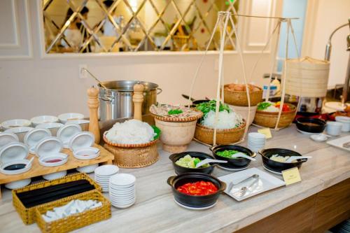 a table topped with bowls and baskets of food at Bantique Hotel in Da Nang