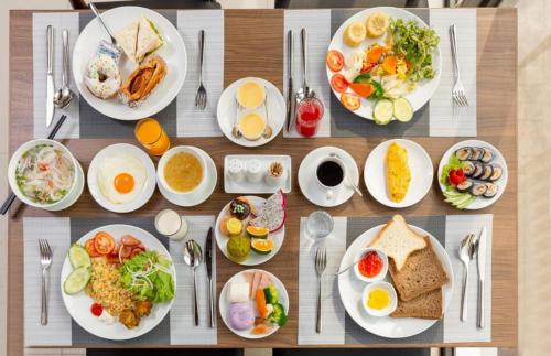 a wooden table with plates of food on it at Bantique Hotel in Da Nang
