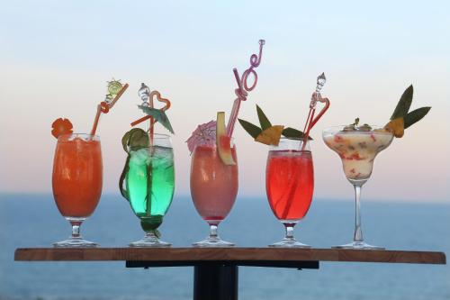 a group of four different colored drinks in glasses at Bantique Hotel in Da Nang