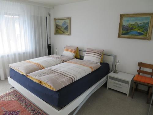 ein Schlafzimmer mit einem Bett mit einer blauen und weißen Matratze in der Unterkunft Villa Franca U06 in Arosa