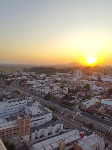 a view of a city with the sunset in the background at Flat completo in Campos dos Goytacazes