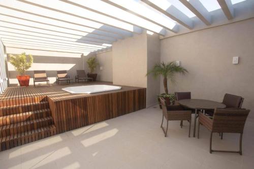 a living room with a table and chairs and a ceiling at Flat completo in Campos dos Goytacazes