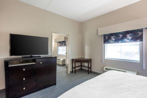 a hotel room with a bed and a flat screen tv at Best Western Plus Wilkes Barre-Scranton Airport Hotel in Pittston
