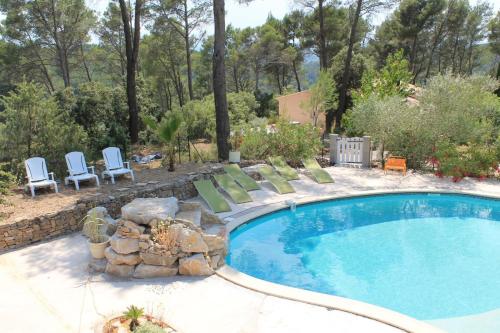 - une piscine avec des chaises longues à côté d'une cour dans l'établissement Villa Coronille calme et nature, à Entrecasteaux