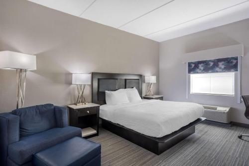 a hotel room with a bed and a blue chair at Best Western Plus Wilkes Barre-Scranton Airport Hotel in Pittston