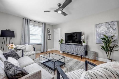 a living room with a couch and a tv at Chic Waterfront Apartment in Downtown San Marco in Jacksonville