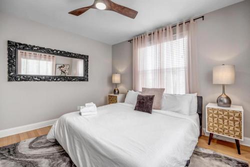a bedroom with a white bed and a ceiling fan at Chic Waterfront Apartment in Downtown San Marco in Jacksonville