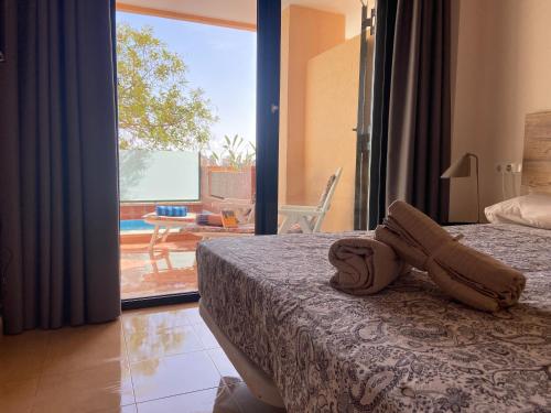 a bedroom with a bed and a view of a patio at Lujoso Apartamento en el tranquilo Resort Hacienda del Alamo in Murcia