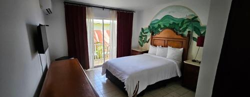 Una habitación de hotel con una cama y una ventana. en Selva Boutique Hotel - Luquillo Oceanfront Retreat - Adults Only, en Luquillo