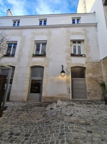 - un grand bâtiment blanc avec deux fenêtres et une porte dans l'établissement A pearl of Paris, à Paris