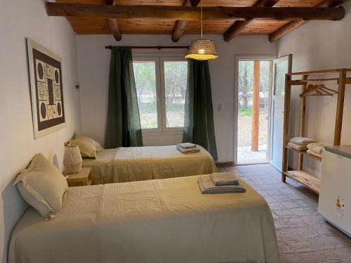 a bedroom with two beds and a window at Casa Natu- Naturaleza in San Marcos Sierras