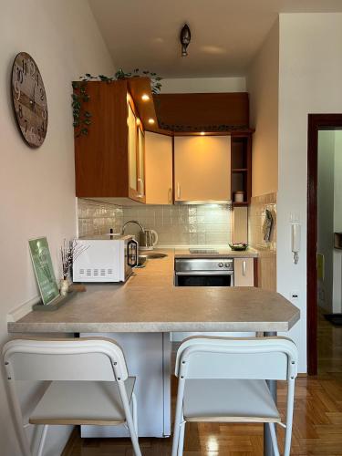 a kitchen with a counter and two stools at Twins Osijek - private parking in Osijek