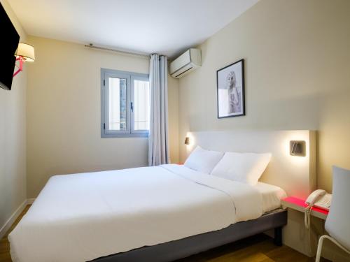 a bedroom with a large white bed and a window at B&B HOTEL Antibes Juan-les-Pins in Juan-les-Pins