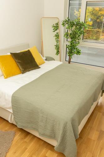a bedroom with a large white bed and a plant at Eggenberg City Suites - Self Check-In in Graz