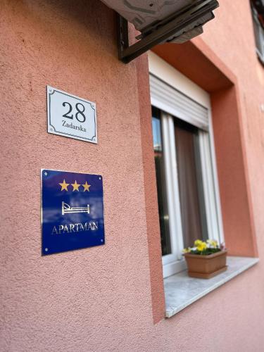 a sign on the side of a building with a window at Twins Osijek - private parking in Osijek
