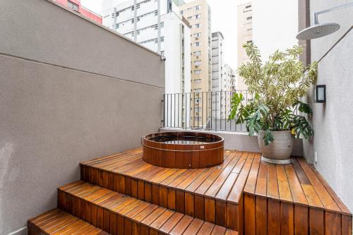 um deck de madeira com uma planta em vaso na varanda em Next Paulista by Viva - Apartamentos completos ao lado da Av Paulista e MASP em São Paulo