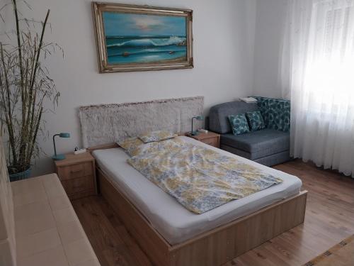 una camera da letto con un letto e una sedia di Mézeskalács vendégház a Balatonboglár