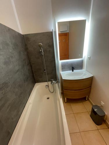 une salle de bain avec une baignoire, un lavabo et un miroir dans l'établissement T2 Alba Rossa n 141 Confort, Panorama Mer Incroyable, à Serra-di-Ferro