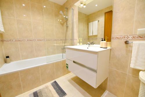 a bathroom with a sink and a shower and a tub at Farinha's Apartment in Ribeira Brava