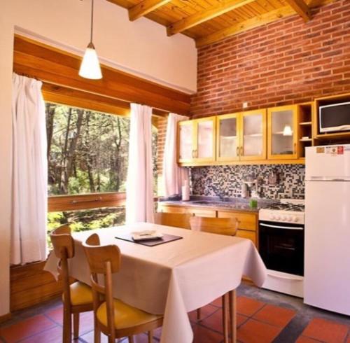 a kitchen with a white table and a white refrigerator at Avalon Apart in Mar de las Pampas