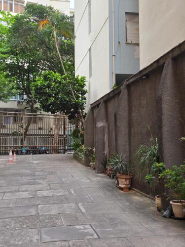 an empty sidewalk next to a building with plants at apartment cool & seafront Arpoador in Rio de Janeiro