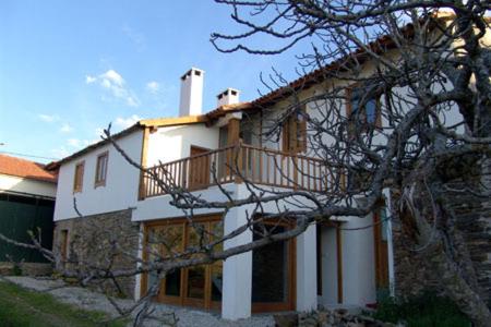 a building with a balcony on the side of it at Casa da Fonte de Travanca in Travanca