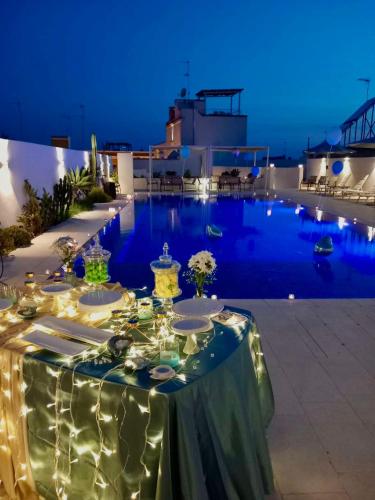 a table set up for a party by the pool at night at Zahra Superior Suite with private pool in Sannicola