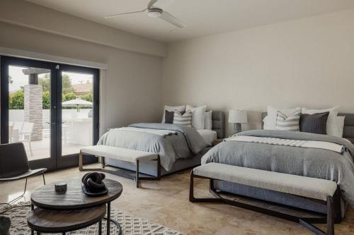 Un dormitorio con dos camas y una mesa. en Riviera - Lazy River Pool, Pickleball, Game Room!, en Bermuda Dunes