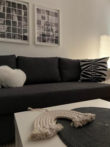 a black couch in a living room with a rug at Zen Suite in Novi Beograd
