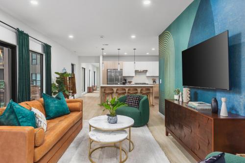 a living room with a couch and a tv at Luxury in The Gulch with Patio Pool Walk to Broadway in Nashville