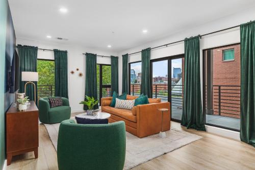 a living room with a couch and chairs and windows at Luxury in The Gulch with Patio Pool Walk to Broadway in Nashville
