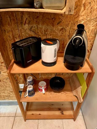 a shelf with a coffee maker and appliances on it at Hébergement Saint Martin d Auxigny in Saint-Martin-dʼAuxigny