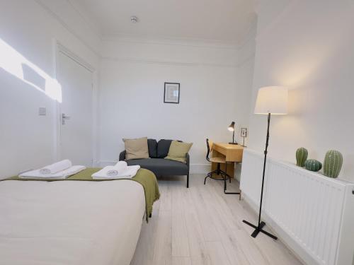 a bedroom with a bed and a chair and a desk at Leyton House - SleepyLodge in London