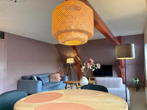 a living room with a table and a couch at Elegant appartement in Pakhuis Friesland centrum in Leeuwarden