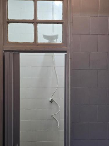 a bathroom with a window and a shower with a hose at apartment cool & seafront Arpoador in Rio de Janeiro