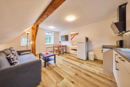 a living room with a couch and a kitchen at Apartmány Rudník Bolkov in Rudník